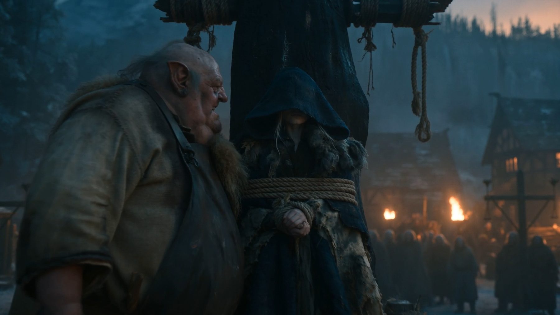 Seedance still — the executioner leans into Aelira tied to the post